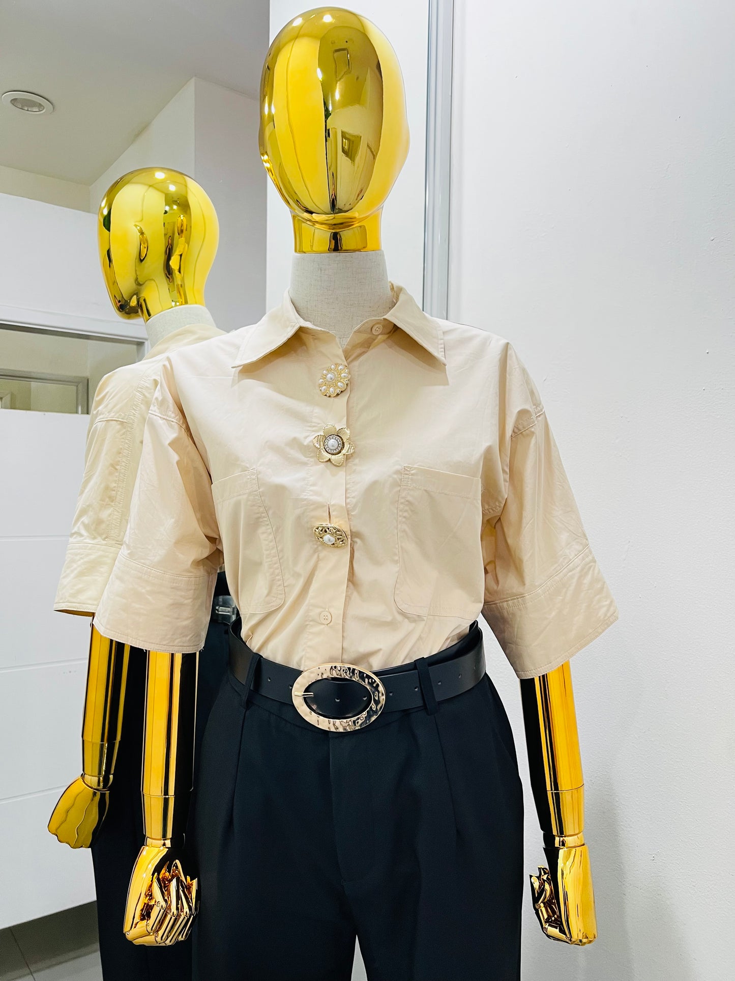 Camisa beige con botón dorado