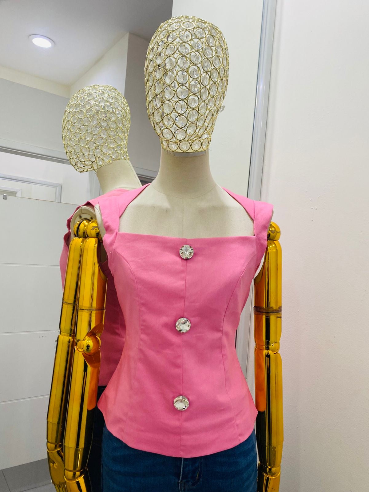 Blusa rosa con botón de diamante