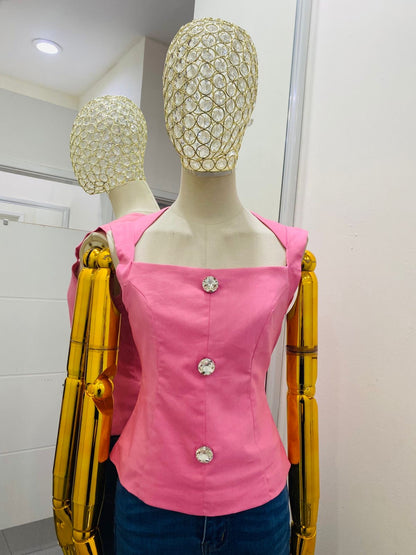 Blusa rosa con botón de diamante